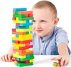 A young boy is playing with a Jenga-like tower of colorful wooden blocks. Podgląd zdjęcia produktu