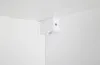 A white corner bracket with a small light fixture attached to it, mounted on a white wall and ceiling. Podgląd zdjęcia produktu