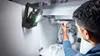 A person is working under a sink with a portable work light illuminating the area. Anteprima dell’immagine prodotto