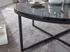 A close-up view of a round coffee table with a black marble-look top and a black metal frame, placed on a gray rug. Produktbild-Vorschau