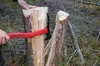 A person is using a STUBAI handsappel to split a log in a forest setting. Produktbild-Vorschau