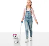 A young girl is walking a toy dog on a leash. Náhled obrázku produktu