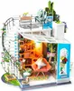 A miniature dollhouse with a staircase, furniture, and plants. Anteprima dell’immagine prodotto