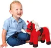 A young boy is sitting next to a red stuffed horse toy. Podgląd zdjęcia produktu