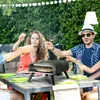 People celebrating outdoors with sparklers and a pizza oven. Produktbild-Vorschau