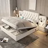 A bedroom scene with a bed that has its storage compartment open, revealing items inside. The bed is the central focus, with ambient lighting and decor suggesting a home environment.