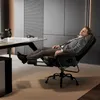 A man in a suit is relaxing in a black ergonomic office chair with his feet up, in a modern office setting. Anteprima dell’immagine prodotto