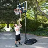 A man is using a basketball hoop in an outdoor setting. Produktbild-Vorschau