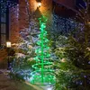 A spiral LED Christmas tree decoration is displayed outdoors at night, surrounded by snow-covered evergreen trees and illuminated by string lights. Náhľad obrázku produktu