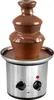 A chocolate fountain with melted chocolate flowing down its tiers, set against a white background. Podgląd zdjęcia produktu