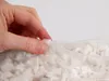 A hand is shown closing a bag of white foam flakes. Produktbild-Vorschau
