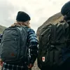 Two people wearing backpacks are hiking in a mountainous area. Náhled obrázku produktu