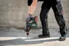 A person is using a cordless hammer drill on a concrete surface. Voir les images du produit