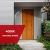 A modern house entrance with a wooden door, illuminated by a wall-mounted LED lamp. Náhled obrázku produktu