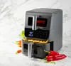 A gray air fryer with a digital display and two baskets, surrounded by fresh vegetables and chili peppers on a marble countertop. Anteprima dell’immagine prodotto