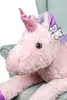 A close-up of a plush unicorn toy sitting on a chair. Podgląd zdjęcia produktu