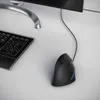 A close-up view of a black ergonomic vertical mouse and a black keyboard on a white desk. Produktbild-Vorschau