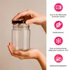 Hands holding a glass jar with a black lid, with icons and text describing its features on the right side. Produktbild-Vorschau