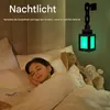 A young girl sleeping in a bed with a night light on the wall. Produktbild-Vorschau