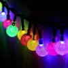 Nahaufnahme einer mehrfarbigen LED-Lichterkette mit strukturierten, blasenartigen Birnen, die im Dunkeln leuchten Produktbild-Vorschau