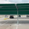 Cars parked under a green shade structure in a parking lot. Náhľad obrázku produktu
