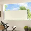 A cream-colored retractable side awning is extended on a balcony, with trees and sky visible in the background. Anteprima dell’immagine prodotto