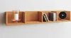 A wooden shelf mounted on a white wall, displaying decorative items and CDs. Produktbild-Vorschau