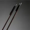 Two dark-colored tongs with wooden handles are shown diagonally against a dark gray background. Anteprima dell’immagine prodotto