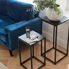 A blue sofa and two black metal side tables in a living room setting. Produktbild-Vorschau