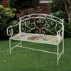 A white metal garden bench with a floral and butterfly patterned cushion sits on a green lawn. Podgląd zdjęcia produktu