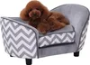 A small brown poodle dog is lying on a gray pet sofa with a chevron pattern on the sides. Náhled obrázku produktu