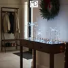 A hallway decorated for Christmas with lighted gift decorations on a console table. Podgląd zdjęcia produktu