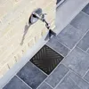 A close-up view of a drain grate and a faucet on a brick wall. Produktbild-Vorschau