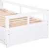 A close-up view of the side and slatted base of a white wooden daybed. Náhled obrázku produktu