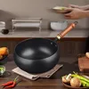 A hand is placing a plate of food into a wok on a kitchen counter. Produktbild-Vorschau