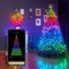 A decorated Christmas tree with multicolor lights, a wreath, and a smartphone displaying a lighting app. Náhled obrázku produktu
