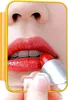 A close-up shot of a person applying red lipstick, with a yellow border around the image. Voir les images du produit