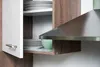 A close-up view of a kitchen cabinet with plates and a bowl. Produktbild-Vorschau