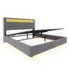 A grey upholstered bed frame with a lifted headboard revealing storage space and hydraulic lift mechanism, against a white background. Anteprima dell’immagine prodotto