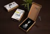 A product shot of a TROIKA keychain in its packaging, with a key and another box in the background. Produktbild-Vorschau