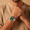 A close-up shot of a person wearing a watch on their wrist. Produktbild-Vorschau
