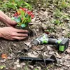 Hands planting a flower with a drill and auger bits nearby. Podgląd zdjęcia produktu