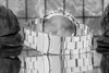 A close-up, black and white shot of a watch clasp and bracelet, with rocks in the background. Produktbild-Vorschau