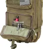 A close-up view of an open pocket on a green military-style backpack, showing a red object and a set of keys. Voir les images du produit