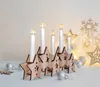 A wooden star-shaped candle holder with LED candles, surrounded by Christmas decorations. Voir les images du produit
