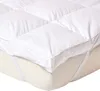 Close-up shot of a white mattress topper on a mattress. Náhled obrázku produktu