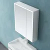 A white bathroom cabinet with LED lighting is mounted on a blue textured wall above a white sink. Produktbild-Vorschau
