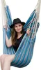 A woman wearing a black hat sits in a blue and white striped hammock chair. Anteprima dell’immagine prodotto