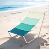 A striped beach chair on a sandy beach with the ocean in the background. Náhled obrázku produktu
