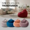 A living room scene with a sofa, coffee table, and beanbags, along with text overlay. Voir les images du produit